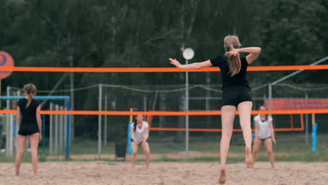 Women-Competing-in-a-Professional-Beach-Volleyball-Tournament.-A-defender-attempts-to-stop-a-shot-during-the-2-women-international-professional-beach-volleyball.